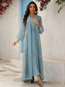 Detail of light blue abaya set featuring golden palm leaf embroidery and elegant gold piping