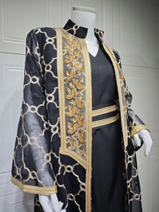 Detail der schwarzen nahöstlichen Abaya mit aufwendiger Goldblatt-Paillettenstickerei und Tüll
