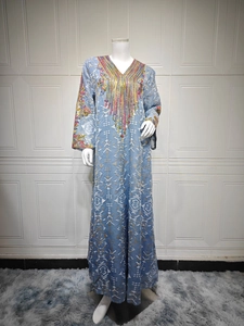 Détail du col en V avec broderie de paillettes colorées sur robe caftan bleu clair