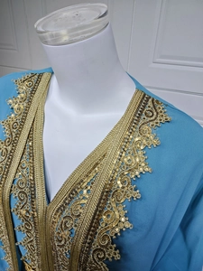 Detailed embroidery and sequins on blue chiffon dress neckline with gold trim