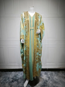 Detail of mint green caftan with gold floral embroidery and sequin lace trimming