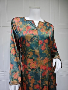 Detail of dark green floral dress featuring gold beaded lace trim and satin texture