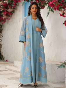Detail of light blue dress with elegant gold palm leaf embroidery and sheer cardigan
