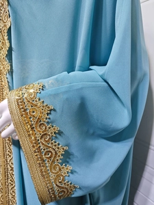 Detail of light blue chiffon abaya with golden sequin embroidery on sleeve cuffs
