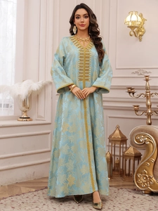 Detail of gold floral embroidery and sequins on light blue kaftan dress neckline