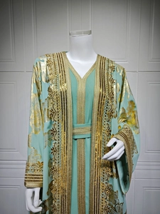 Detailed view of mint green kaftan dress with golden sequin embroidery and intricate lace