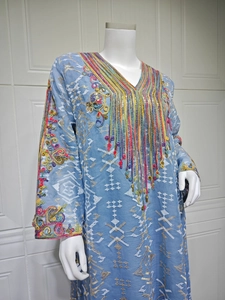 Détail de broderie multicolore et perles complexes sur robe caftan en mesh bleu clair