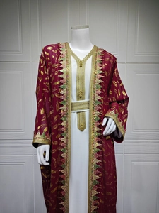 Détail du caftan bordeaux avec broderie plume dorée et bordure à pompons pailletés