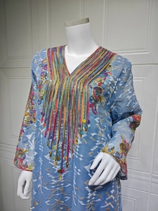 Détails de broderies colorées et paillettes sur robe de soirée en tulle bleu clair