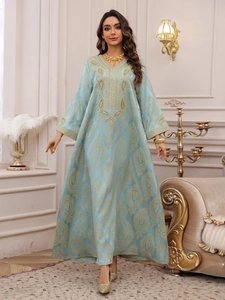 Détail de la robe caftan bleu clair avec broderies dorées et décolleté en V élégant