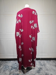 Vue détaillée du dos d'une robe longue bordeaux avec broderies dorées et sequins floraux