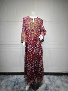 Detail of burgundy long dress with heavy golden ethnic embroidery on the neckline and sleeves
