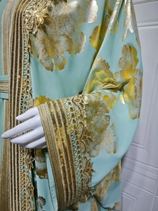 Macro detail of luxury gold embroidery and sequins on mint green party dress kaftan