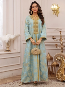Detail of light blue kaftan dress featuring gold leaf jacquard and intricate sequin embroidery