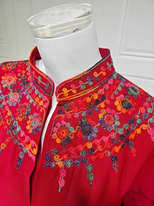 Detail of red Chinese stand collar top featuring intricate colorful floral bead embroidery