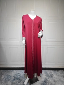 Détail de la broderie argentée sur robe abaya rouge foncé à col en V et manches longues