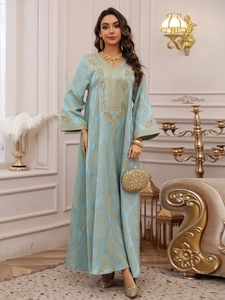 Détail de la robe caftan bleu clair avec broderies dorées et accessoires de luxe assortis