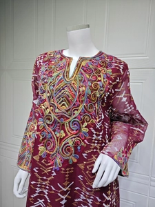 Close-up of ethnic wine red tunic featuring intricate floral embroidery and golden sequins