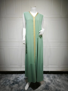 Detail of mint green long dress featuring intricate gold braided trim along the V-neckline