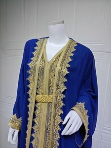Detail of intricate gold embroidery and sequin trim on deep blue chiffon kaftan dress