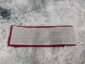 Détail de la ceinture brodée bordeaux avec motif à chevrons en fil métallique argenté