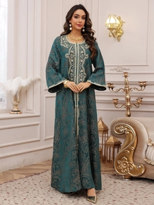Close-up of vintage floral embroidery and beaded detailing on a dark green kaftan dress