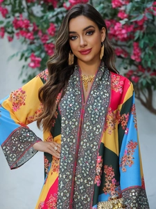 Detail of colorful kaftan dress featuring floral prints and ethnic neckline embroidery