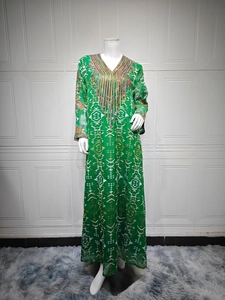 Détail de l'encolure brodée sur une robe caftan verte aux motifs ethniques géométriques