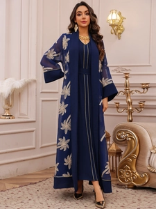 Detailed close-up of golden leaf embroidery on a dark blue two-piece modest abaya dress