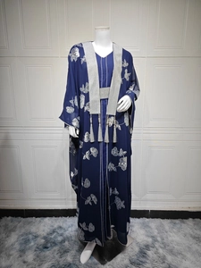 Détail de robe caftan bleu marine avec broderie florale argentée et glands à franges