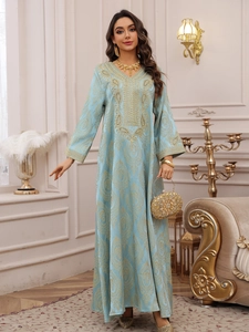 Détails de broderie dorée sur caftan en jacquard bleu clair avec finitions luxueuses