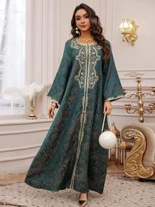 Detail of gold embroidery and beadwork on a dark green Kaftan evening dress