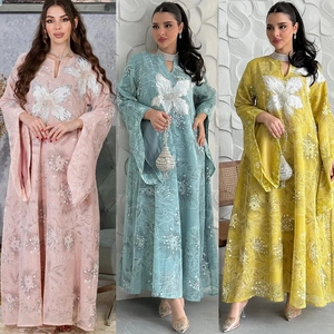 Detailed close-up of sequin floral appliques and embroidery on three colored kaftan dresses