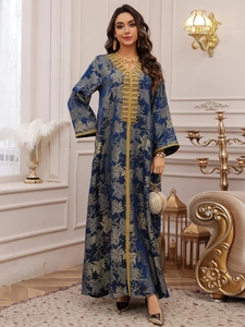 Detail of blue long sleeve dress with golden leaf patterns and embroidered rhinestones