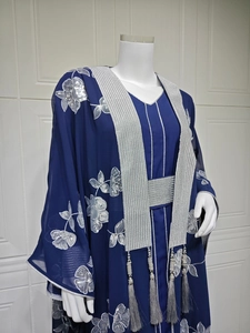 Détail d'Abaya bleu marine avec broderie florale argentée et pompons décoratifs