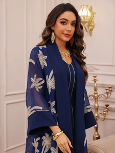 Detailed golden palm leaf embroidery on a dark blue sheer kaftan abaya two-piece set