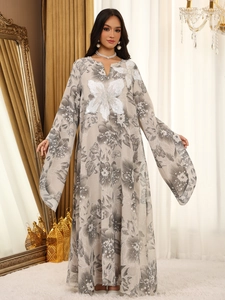 Detail of sequin floral applique on a V-neck maxi dress with wide flare sleeves
