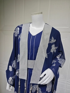 Détails de broderie florale à paillettes argentées et franges sur la robe abaya bleue