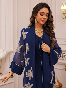 Detailed golden leaf embroidery on navy blue abaya with elegant gold piping accents