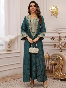Détail de la broderie en dentelle dorée sur la robe de soirée caftan vert foncé