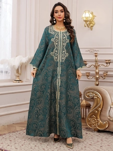 Detailed view of dark green kaftan with intricate gold paisley embroidery and beadwork