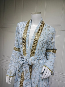Dettaglio di caftano ricamato azzurro con paillettes a specchio e bordi in jacquard dorato