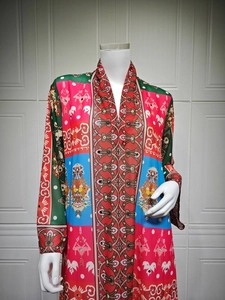 Détail de robe bohème à col en V avec motifs ethniques colorés et accents de paillettes