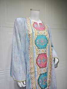 Vue détaillée des broderies ethniques et paillettes sur un caftan bleu clair