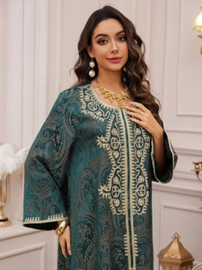 Detail of emerald green Kaftan dress featuring gold embroidery and beaded paisley patterns