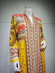Detailed view of bohemian floral print and sparkly sequins on a yellow chiffon maxi dress