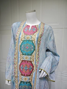 Détail de la robe bleu clair à col en V avec broderie géométrique et paillettes discrètes