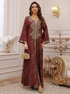 Close-up of intricate gold embroidery and paisley pattern on dark red Kaftan evening dress