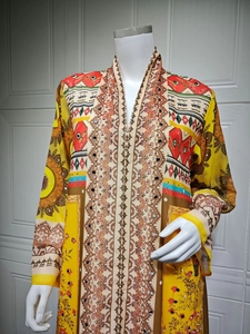 Detail of ethnic floral print kaftan with sequins and mirror accents on yellow chiffon