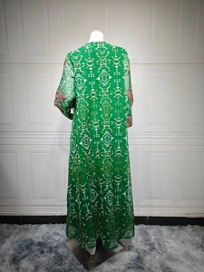 Détail de la robe brodée verte montrant les motifs floraux en mesh et broderies riches